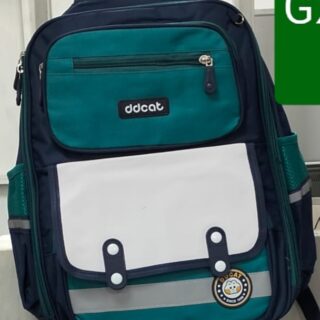 Green and navy blue school backpack with white front pocket and multiple compartments