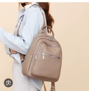 Elegant taupe leather backpack with silver zippers, designed for stylish women travelers – perfect for luxury day trips