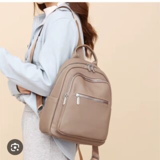 Elegant taupe leather backpack with silver zippers, designed for stylish women travelers – perfect for luxury day trips