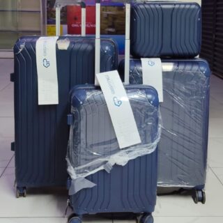 Set of 4 navy blue hard shell suitcases with spinner wheels, including carry-on and travel bag.