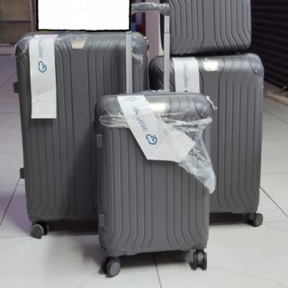 Set of 4 gray hard shell suitcases with spinner wheels, including carry-on and travel bag.
