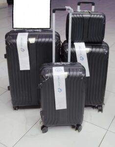 Set of 4 black hard shell suitcases with spinner wheels, including carry-on and travel bag.