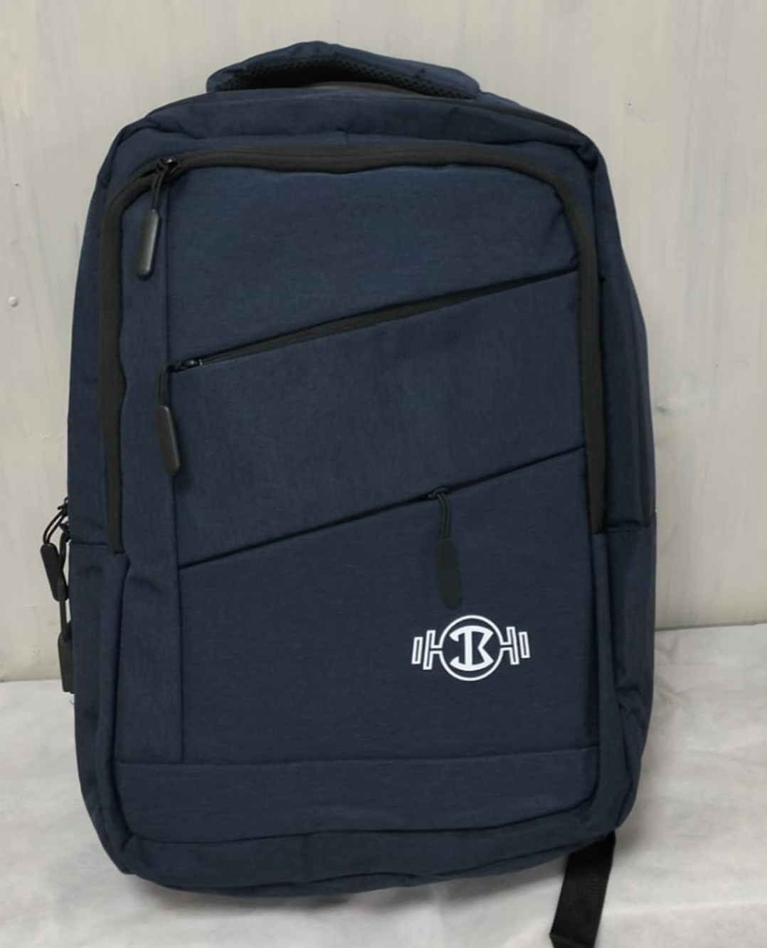A professional navy blue backpack with a minimalist, streamlined design