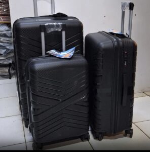 Black carbon-fiber style 3-piece hard shell suitcase set with spinner wheels and telescopic handles