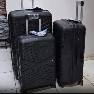 Black carbon-fiber style 3-piece hard shell suitcase set with spinner wheels and telescopic handles