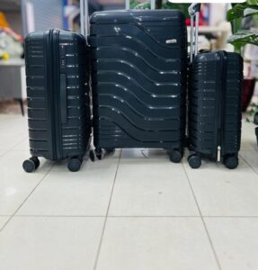 Black hard-shell 3-piece luggage set with wave and ribbed design, spinner wheels, and telescopic handle.