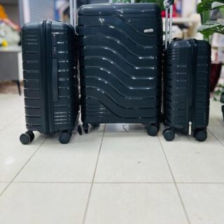Black hard-shell 3-piece luggage set with wave and ribbed design, spinner wheels, and telescopic handle.