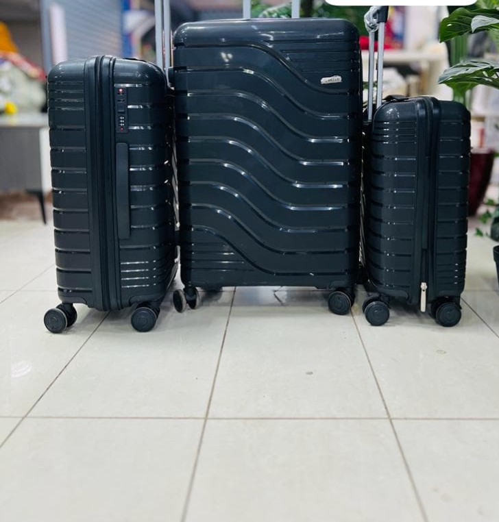 Black hard-shell 3-piece luggage set with wave and ribbed design, spinner wheels, and telescopic handle.