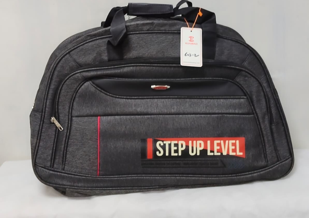 Black duffel travel bag with “STEP UP LEVEL” design in red and white print