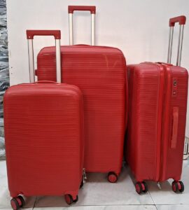 Three red hard-shell rolling suitcases of different sizes with telescopic handles