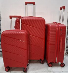 A set of three red hard-shell rolling suitcases in large, medium, and small sizes.