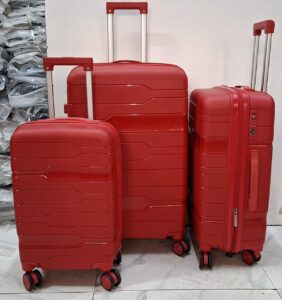 A set of three red hard-shell rolling suitcases in large, medium, and small sizes.