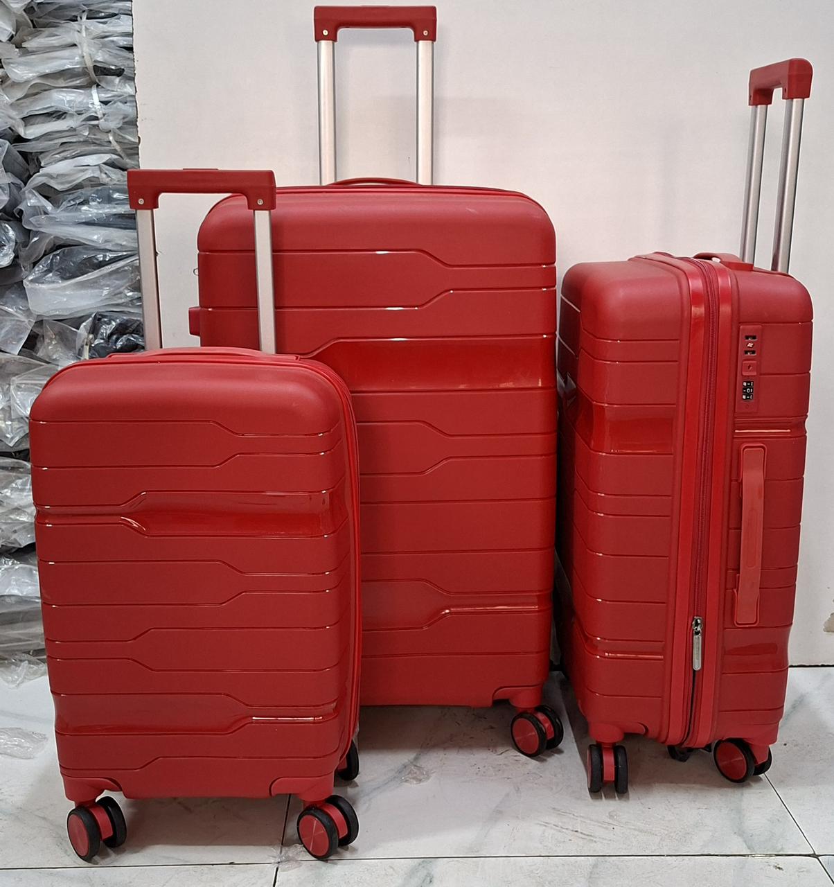 A set of three red hard-shell rolling suitcases in large, medium, and small sizes.