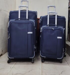 Set of four navy blue expandable suitcases with spinner wheels and telescopic handles.
