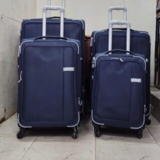 Set of four navy blue expandable suitcases with spinner wheels and telescopic handles.