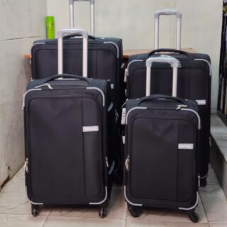 Set of four black expandable suitcases with spinner wheels and telescopic handles.